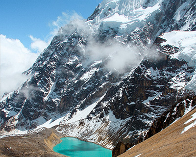 Panoramic view of Ancascocha Lake next to snow-capped mountains