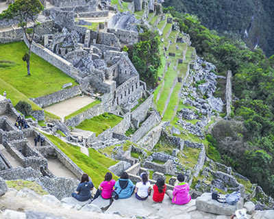 Photo from above the top of tourists sitting resting in MachuPicchu