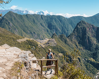 Woman takes a photo from the Inti Punku viewpoint in Machu Picchu