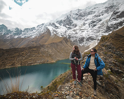 Couple is appreciating the snowy mountain and the Humantay Lake
